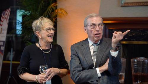 a photo of two alumni speaking at the cocktail party